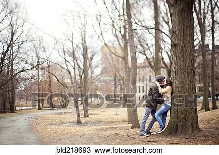 Stock Image - Couple kissing in urban park. Fotosearch