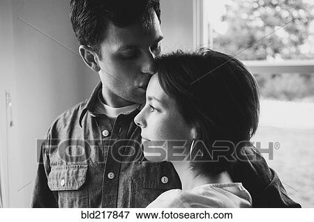 Stock Photo - Couple kissing near window. Fotosearch