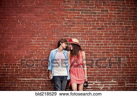 Couple leaning on brick wall View Large Photo Image Stock Photo - Couple leaning on brick wall. Fotosearch
