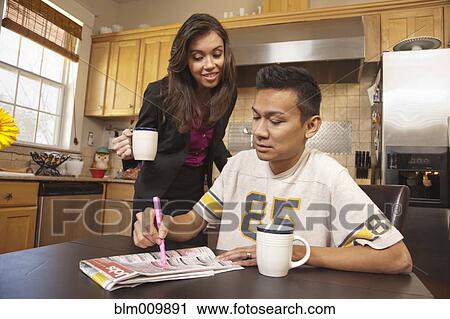 Couple looking at classified ads in kitchen View Large Photo Image Stock Image - Couple looking at classified ads in kitchen. Fotosearch