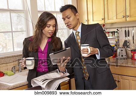 Couple looking at digital tablet in kitchen View Large Photo Image Stock Image - Couple looking at digital tablet in kitchen. Fotosearch