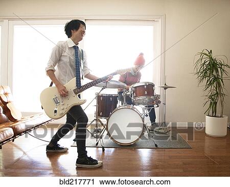 Stock Image - Couple playing music in living room. Fotosearch