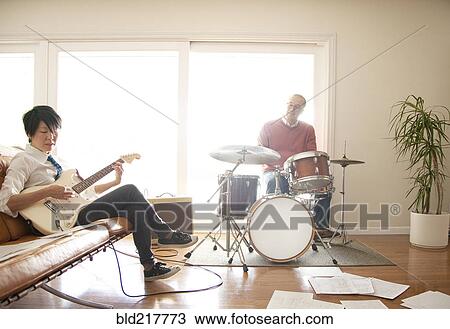 Stock Image - Couple playing music in living room. Fotosearch