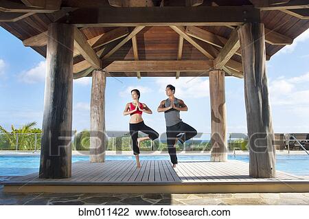 Stock Image - Couple practicing yoga together. Fotosearch