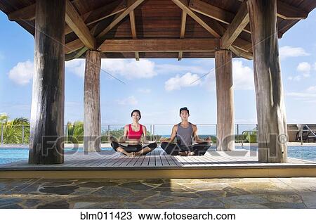 Stock Image - Couple practicing yoga together. Fotosearch