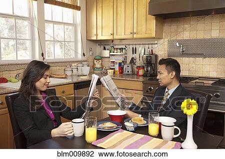 Couple reading newspapers in kitchen View Large Photo Image Stock Image - Couple reading newspapers in kitchen. Fotosearch