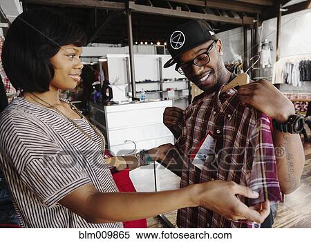 Couple shopping together in clothing store View Large Photo Image Stock Photography - Couple shopping together in clothing store. Fotosearch