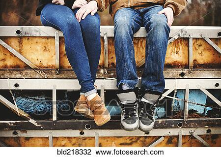 Stock Image - Couple sitting on bleachers in park. Fotosearch