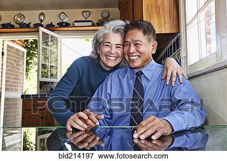 Stock Photo - Couple smiling in kitchen. Fotosearch