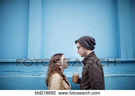Couple standing near blue wall View Large Photo Image Stock Image - Couple standing near blue wall. Fotosearch