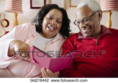 Couple using cell phone in living room View Large Photo Image Stock Image - Couple using cell phone in living room. Fotosearch