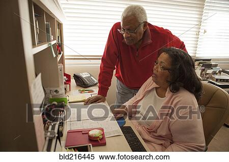 Couple using computer in home office View Large Photo Image Stock Photography - Couple using computer in home office. Fotosearch