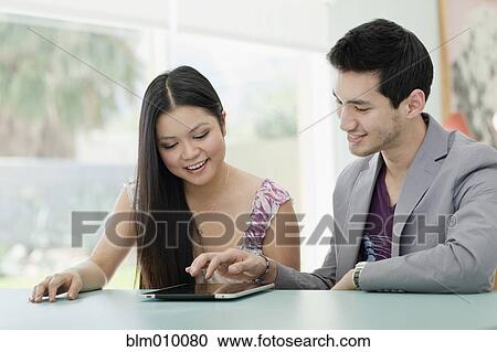 Stock Image - Couple using digital tablet together. Fotosearch