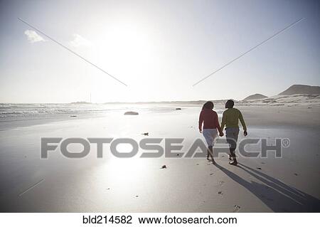 Couple walking on beach View Large Photo Image Stock Image - Couple walking on beach. Fotosearch