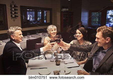 Couples toasting with red wine in restaurant View Large Photo Image Stock Image - Couples toasting with red wine in restaurant. Fotosearch