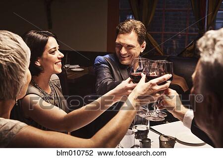 Couples toasting with red wine in restaurant View Large Photo Image Stock Image - Couples toasting with red wine in restaurant. Fotosearch