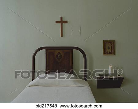 Crucifix over bed in simple bedroom View Large Photo Image Stock Photo - Crucifix over bed in simple bedroom. Fotosearch