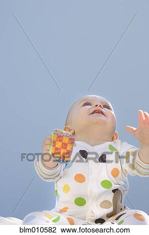 Stock Image - Curious Caucasian baby playing with toy. Fotosearch