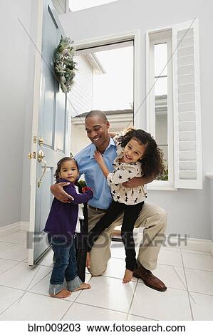 Stock Image - Daughters greeting returning father. Fotosearch