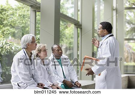 Stock Photography - Doctors talking together in lobby. Fotosearch