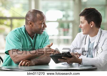 Stock Image - Doctors using digital tablet together. Fotosearch