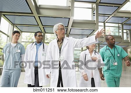 Doctors walking together in lobby View Large Photo Image Stock Image - Doctors walking together in lobby. Fotosearch