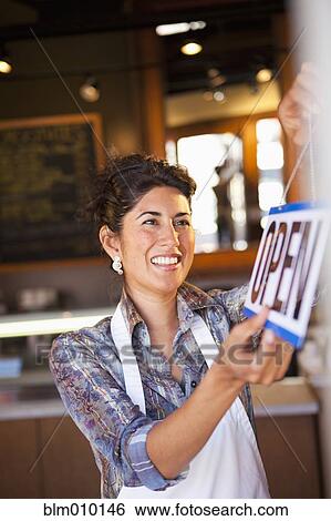 Ecuadorian small business owner hanging "open" sign on door View Large Photo Image Stock Photograph - Ecuadorian small business owner hanging "open" sign on door. Fotosearch