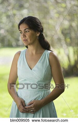 Stock Photography - Elegant Hispanic woman standing outdoors. Fotosearch