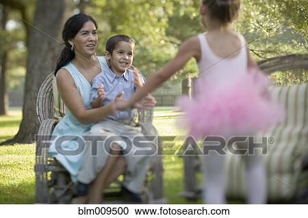 Elegant mother sitting in backyard with children View Large Photo Image Stock Image - Elegant mother sitting in backyard with children. Fotosearch