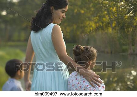 Elegant mother standing near pond with children View Large Photo Image Stock Photo - Elegant mother standing near pond with children. Fotosearch