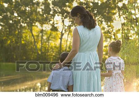 Elegant mother standing near pond with children View Large Photo Image Stock Photograph - Elegant mother standing near pond with children. Fotosearch