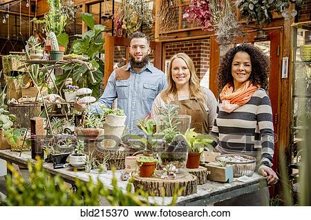 Employee and customers smiling in plant nursery View Large Photo Image Stock Image - Employee and customers smiling in plant nursery. Fotosearch