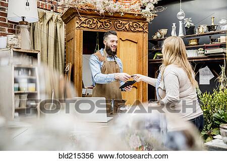 Stock Photograph - Employee helping customer shopping in store. Fotosearch