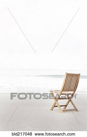 Stock Photo - Empty folding chair on beach. Fotosearch