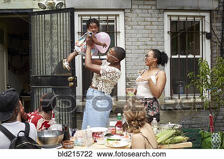 Family enjoying backyard barbecue View Large Photo Image Stock Image - Family enjoying backyard barbecue. Fotosearch