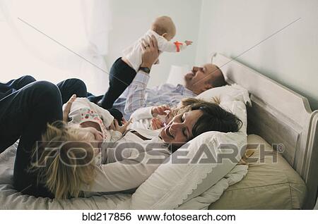Family playing on bed View Large Photo Image Stock Photograph - Family playing on bed. Fotosearch