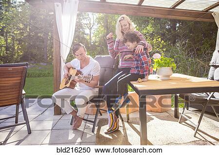 Stock Image - Family relaxing on backyard patio. Fotosearch