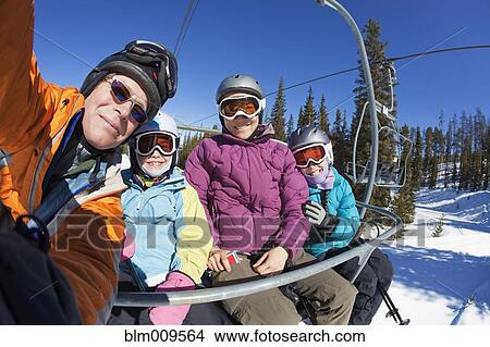 Picture - Family riding ski lift together. Fotosearch