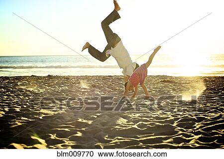 Father and daughter doing cartwheels on beach View Large Photo Image Stock Image - Father and daughter doing cartwheels on beach. Fotosearch