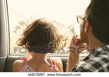Stock Image - Father and daughter looking out car window. Fotosearch