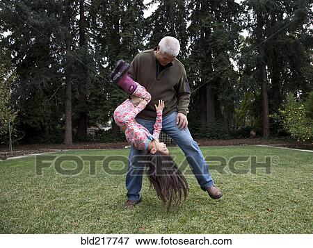 Stock Photo - Father and daughter playing in backyard. Fotosearch