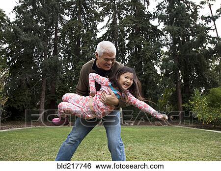 Stock Photograph - Father and daughter playing in backyard. Fotosearch