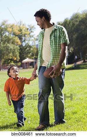 Stock Image - Father and son playing football. Fotosearch