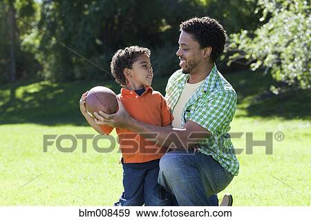Stock Photo - Father and son playing football. Fotosearch