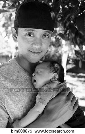 Stock Photography - Father holding newborn baby outdoors. Fotosearch