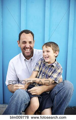 Stock Photo - Father holding son on lap. Fotosearch