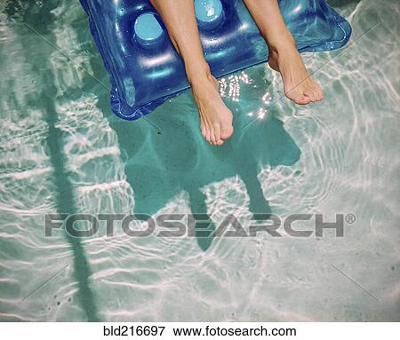 Feet of Caucasian woman floating on raft in swimming pool View Large Photo Image Stock Photo - Feet of Caucasian woman floating on raft in swimming pool. Fotosearch