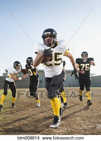 Picture - Football players playing on football field. Fotosearch