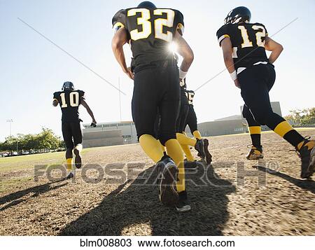 Football players running on football field View Large Photo Image Stock Image - Football players running on football field. Fotosearch