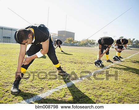 Football players stretching on football field View Large Photo Image Stock Photo - Football players stretching on football field. Fotosearch
